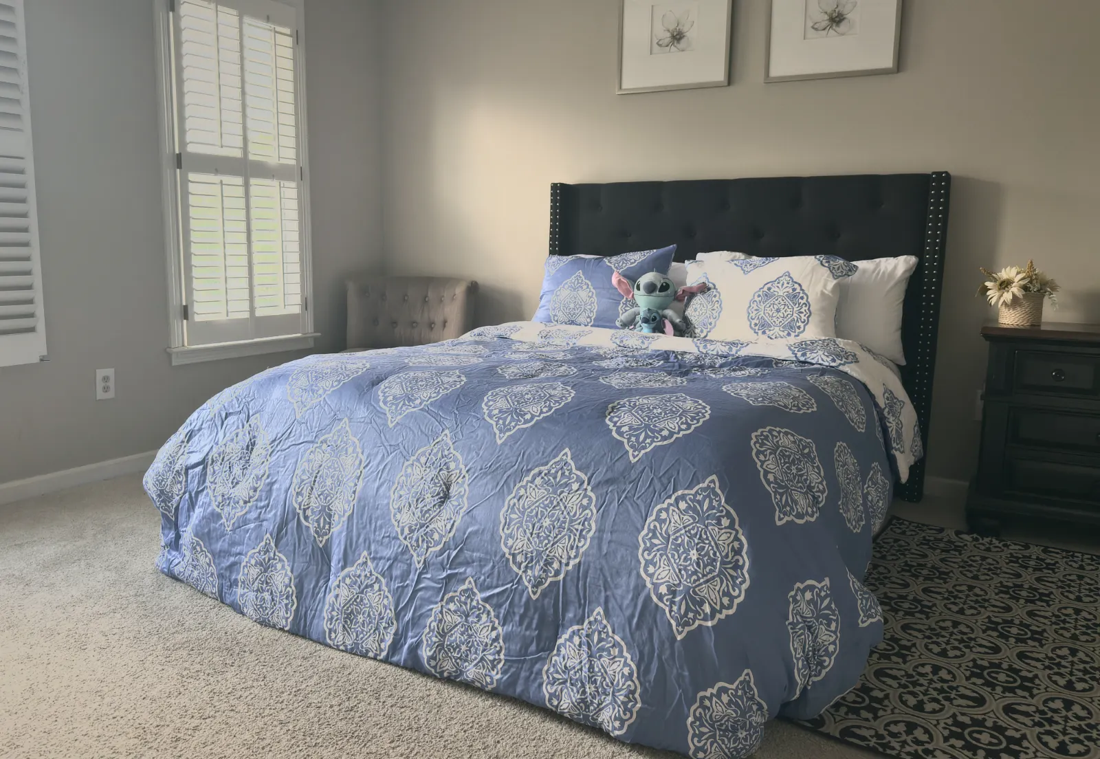 Detail: daylight at the bedroom window above the made bed.